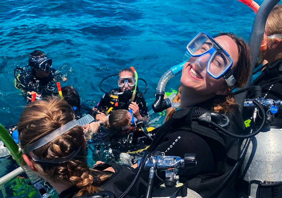 Girl in scuba gear smiling into camera