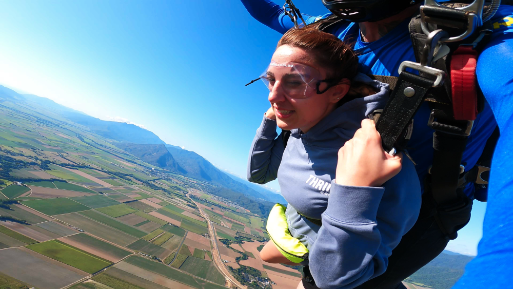 girl parachuting during skydiving in cairns smiling barely.