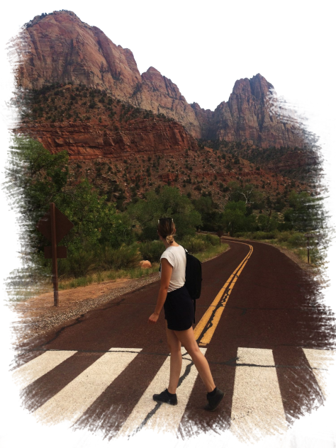 The slowtravelista walking over a street in Zion National Park